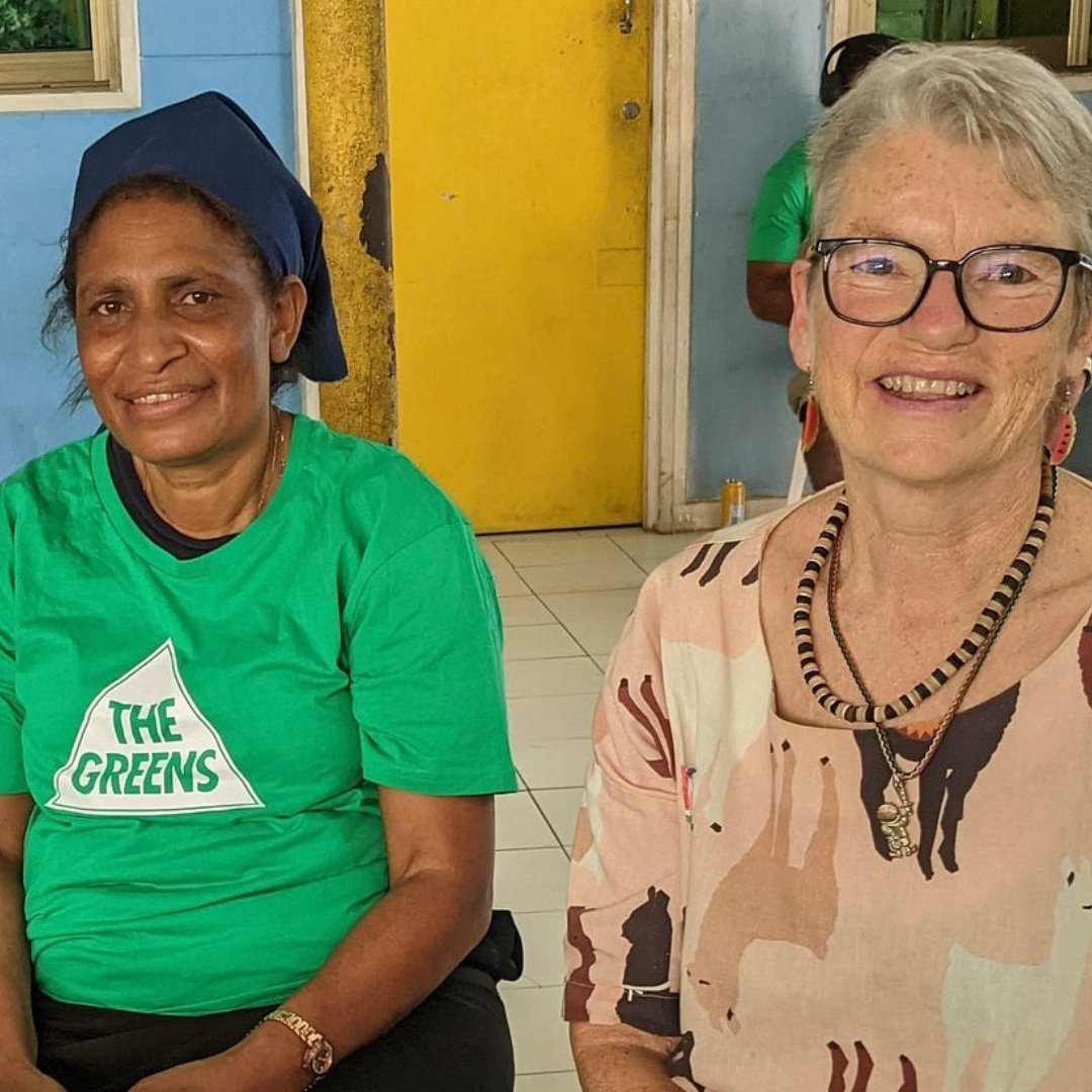 Image of Janet Rice smiling with member of PNG Greens wearing Australian Greens tshirt