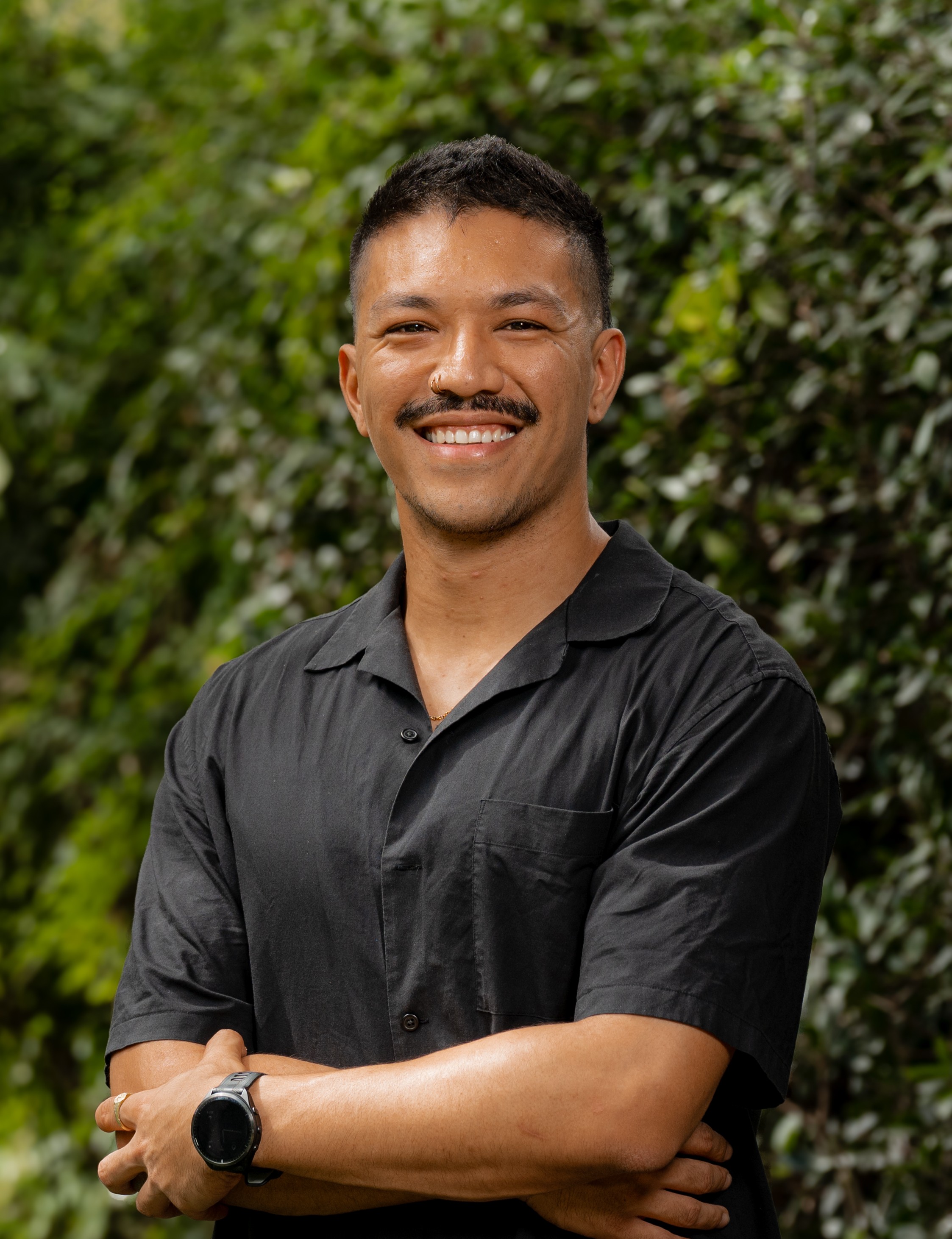 Chris Siclari in front of a green leafy background