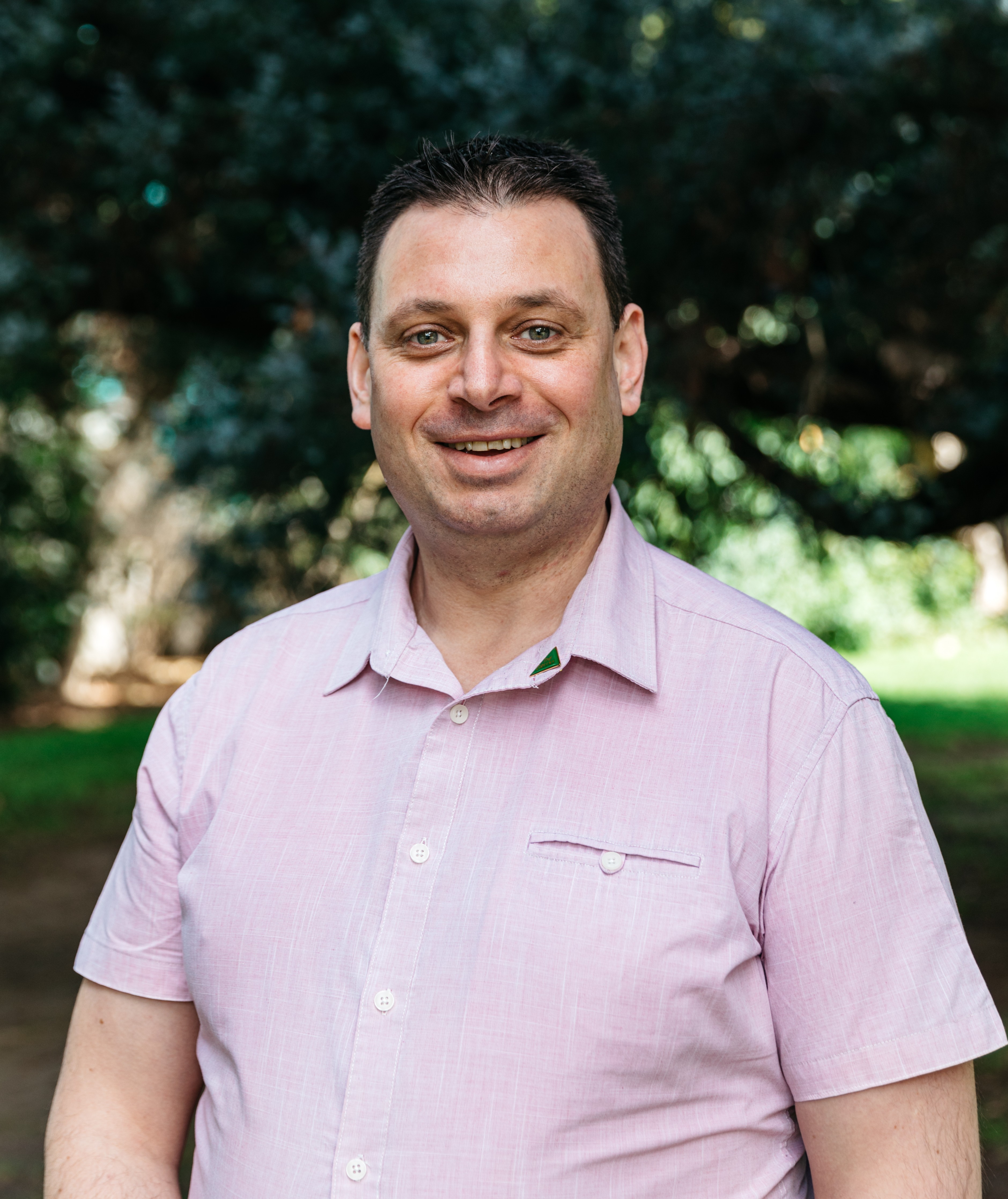 Sean Weatherly in front of a green leafy background