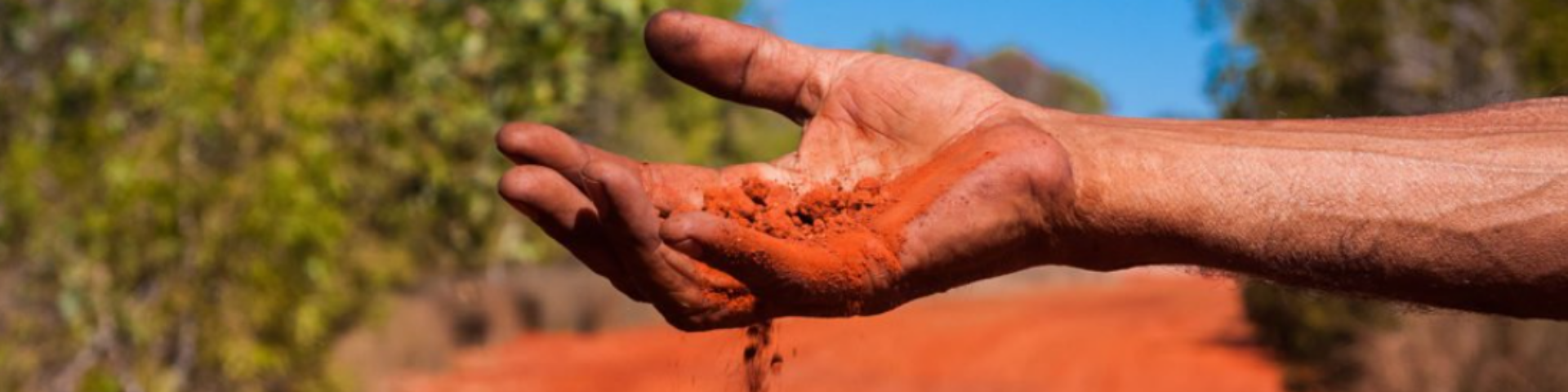 hand holding red dirt