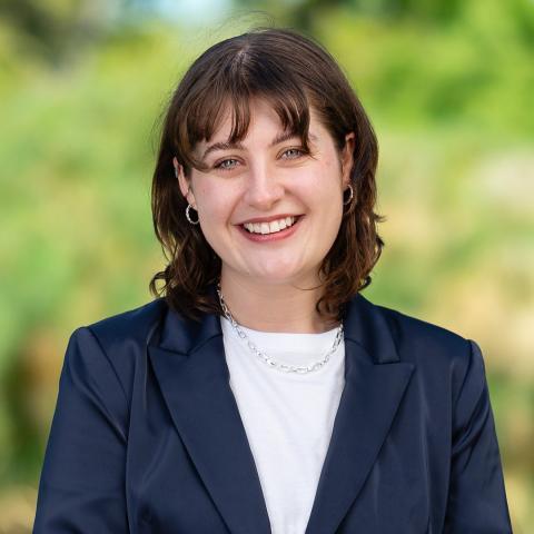 Profile picture of Brittney Henderson, Lead candidate for Western Metropolitcan Region. Brittney is wearing a dark suit and is standing in front of blurred out greenery.