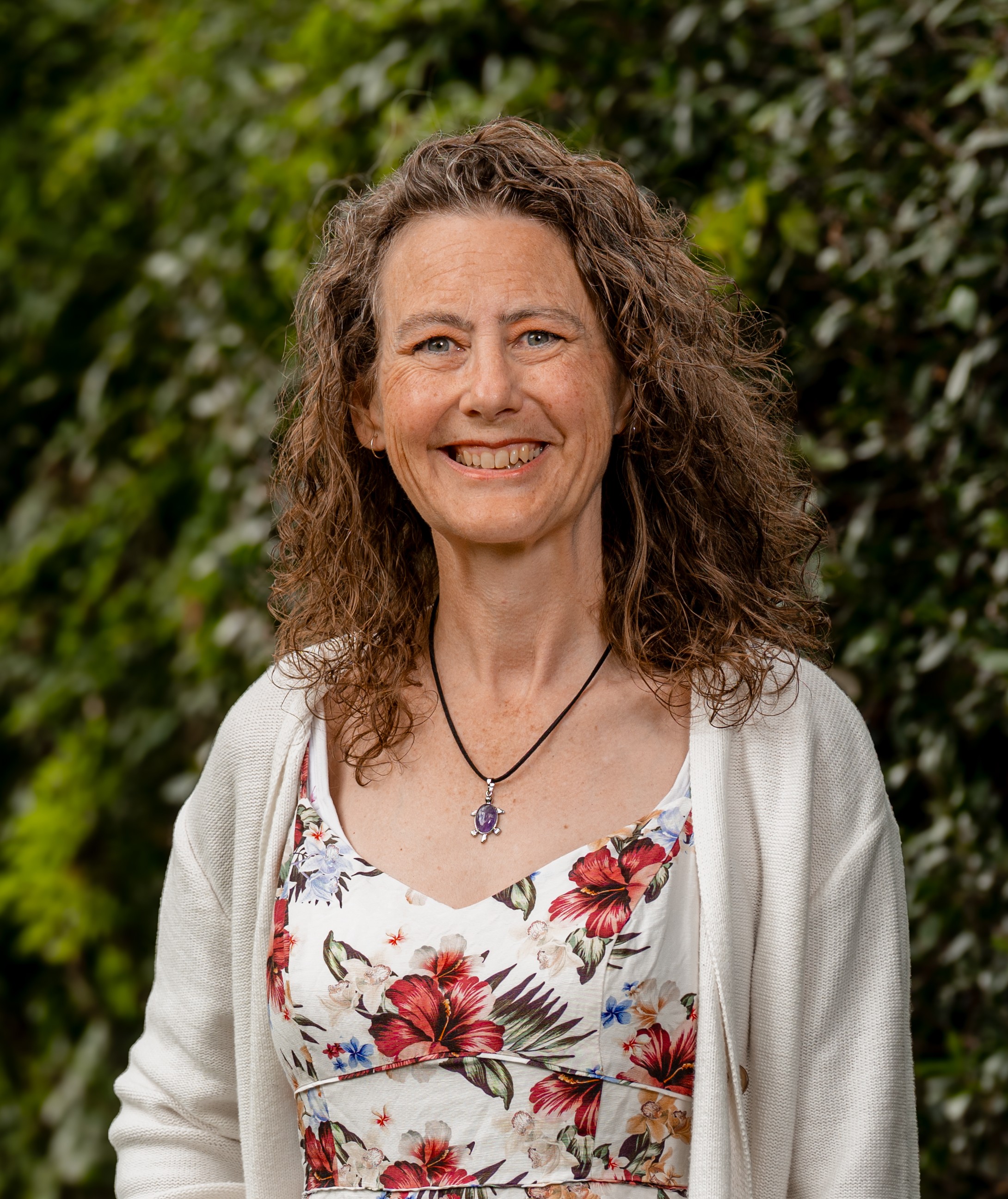 Tammy Scott in front of a green leafy background