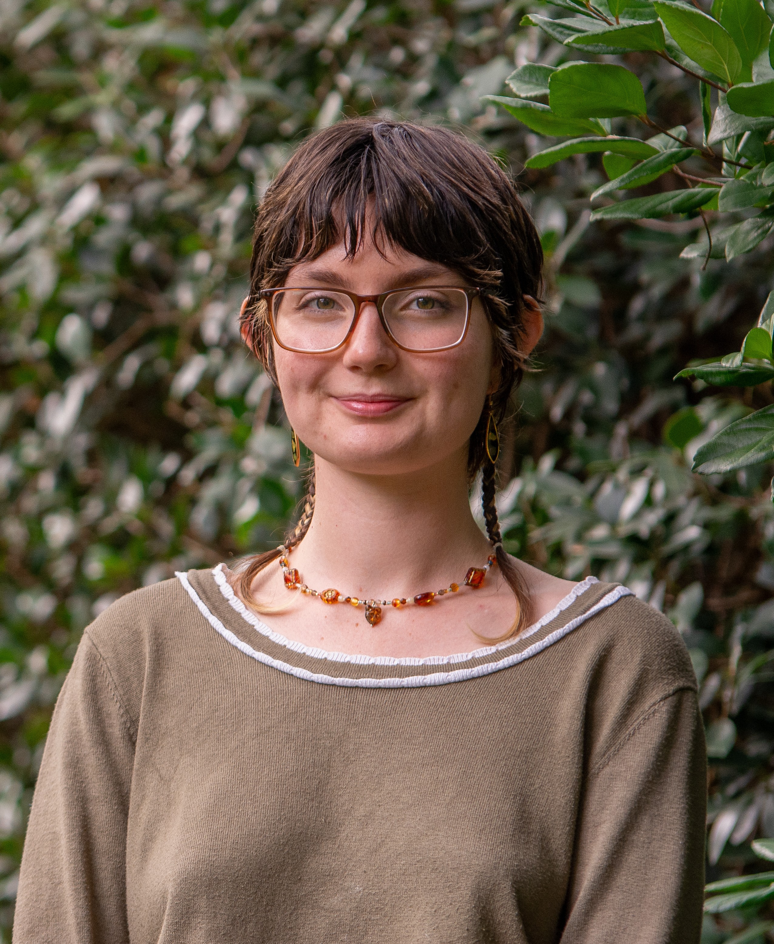 Poppy Pilmore in front of a green leafy background