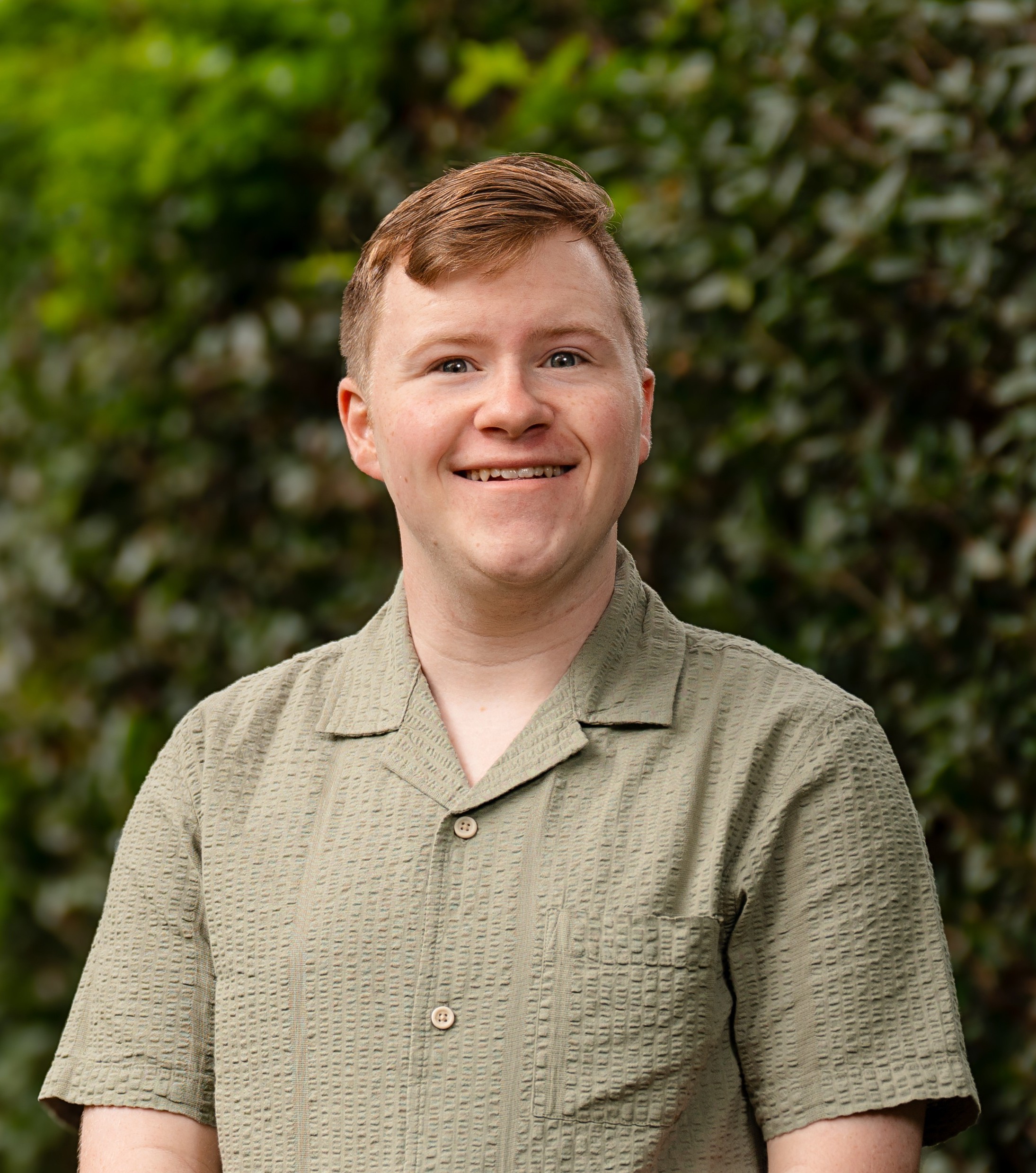 David Deex in front of a green leafy background