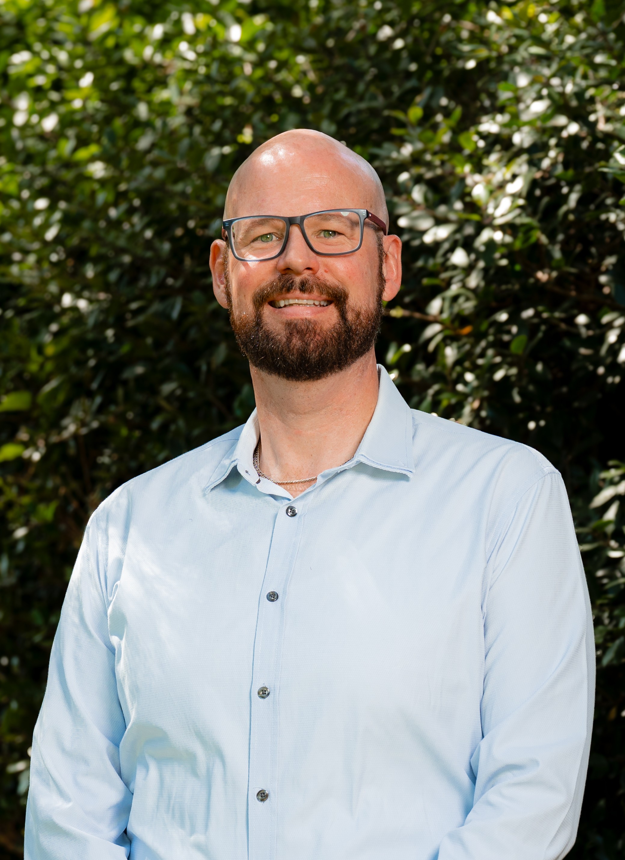 Brett Ferris in front of a green leafy background