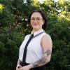 Profile picture of Greens candidate for South-West Coast, Silver Rose. Silver is standing in front of bushes and is wearing a sleaveless white shirt with a thin black tie. Silver is standing slightly to the side while looking at the camera