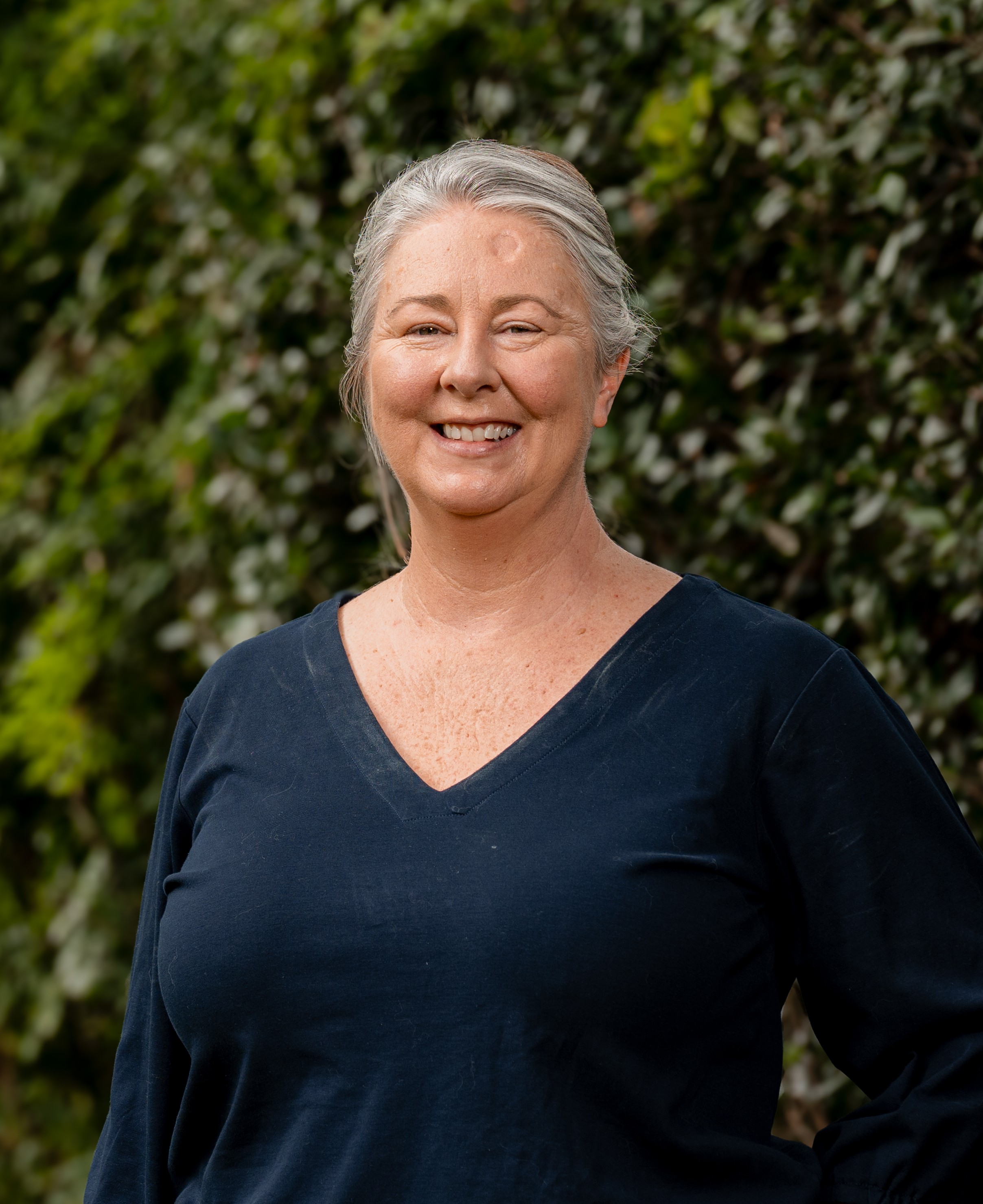 Danielle Every in front of a green leafy background
