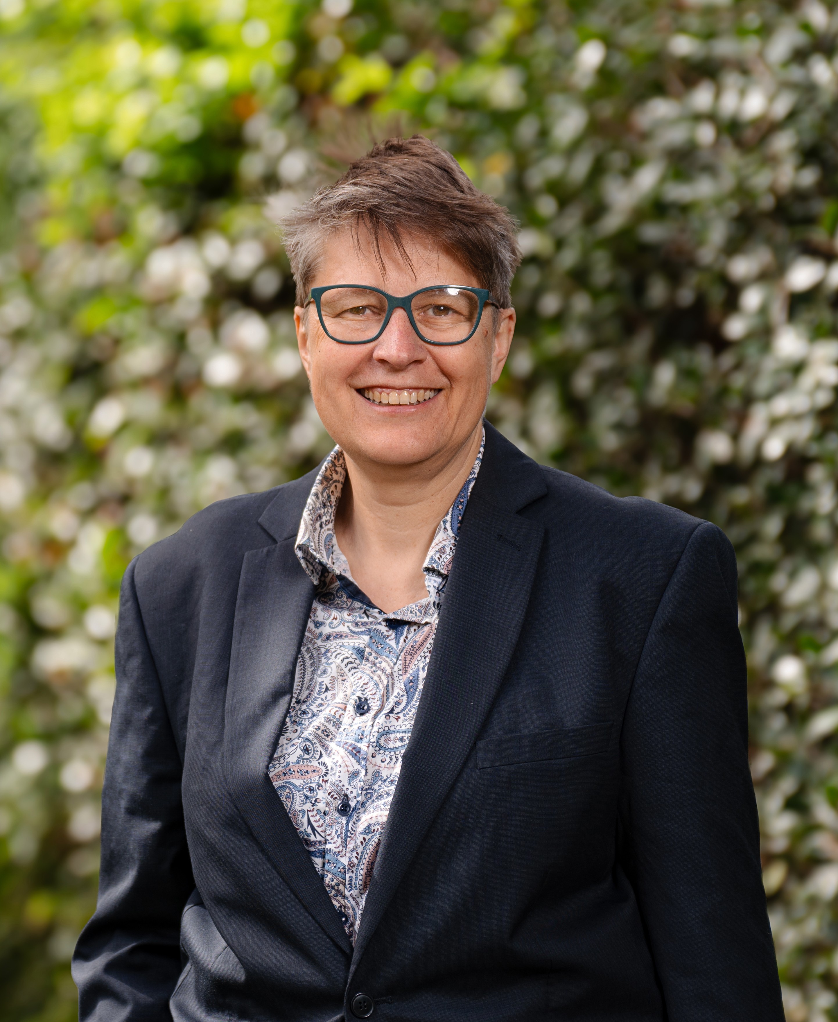 Stef Rozitis in front of a green leafy background