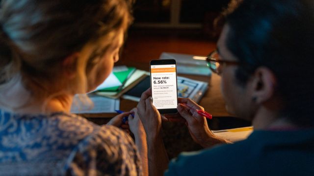A young couple review financial data on a mobile phone