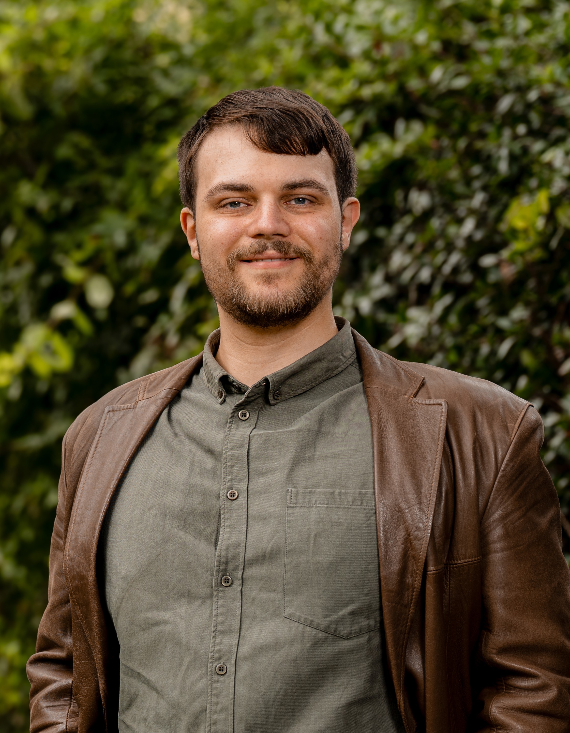 Xander Osborne in front of a green leafy background