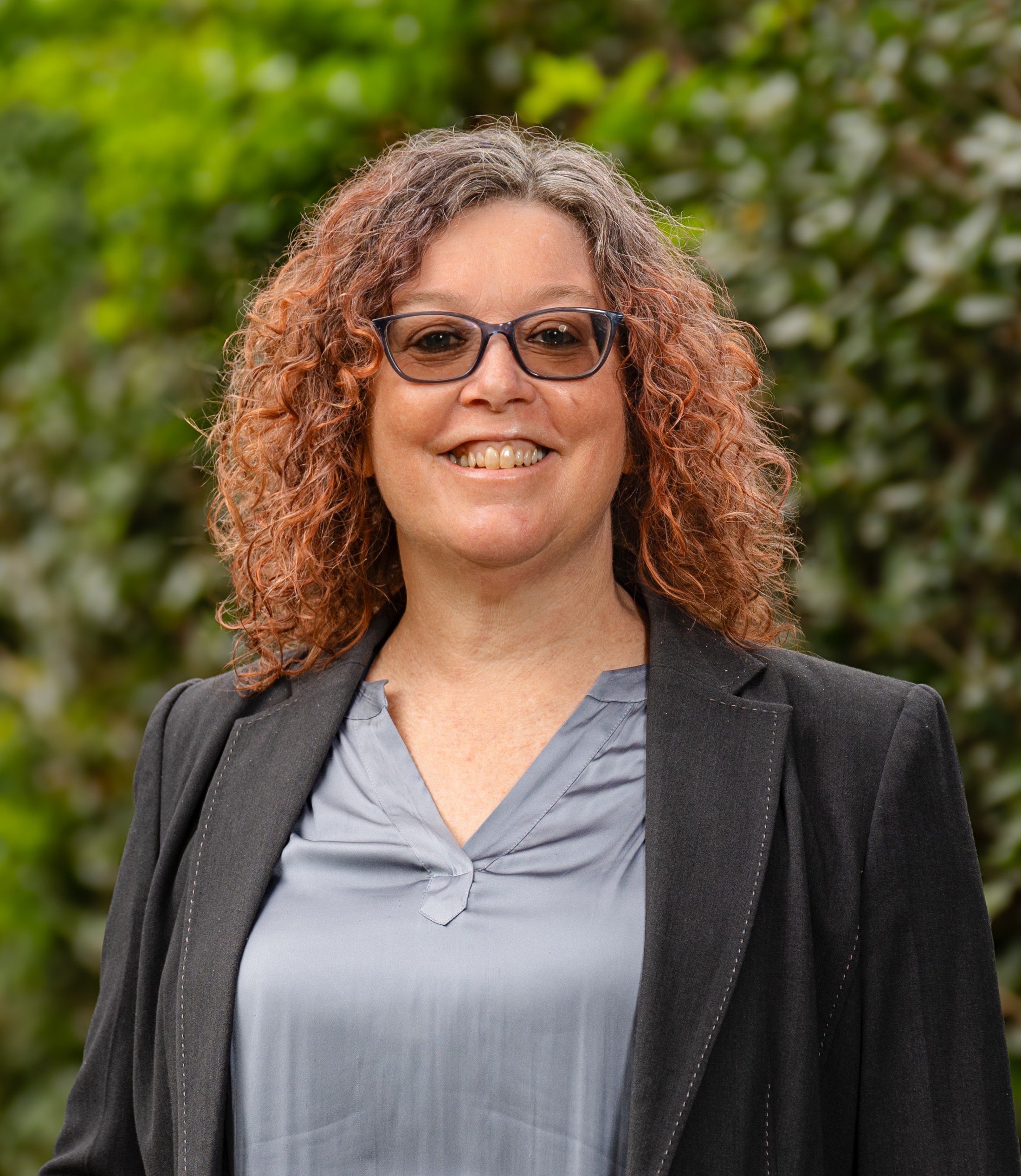Alexandra McGee in front of a leafy green background
