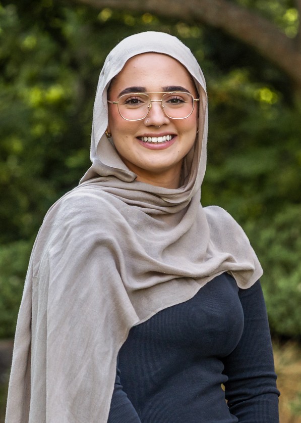 Stella Salvemini in front of a green leafy background