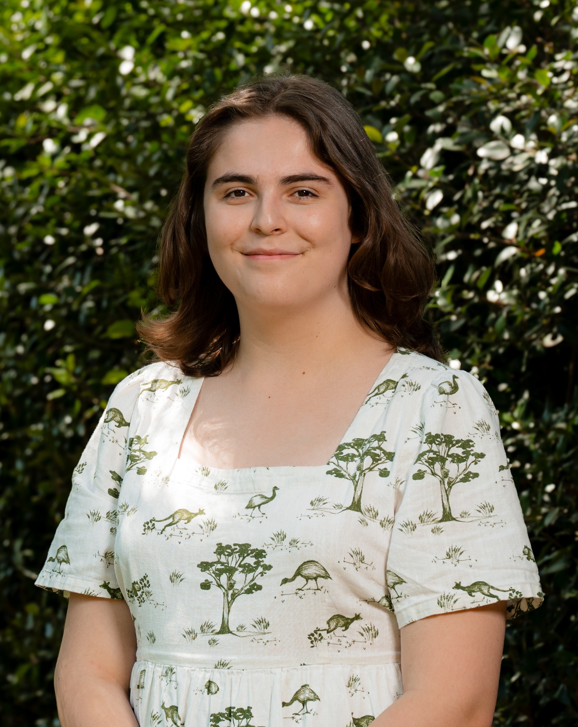 Miya Tait in front of a green leafy background