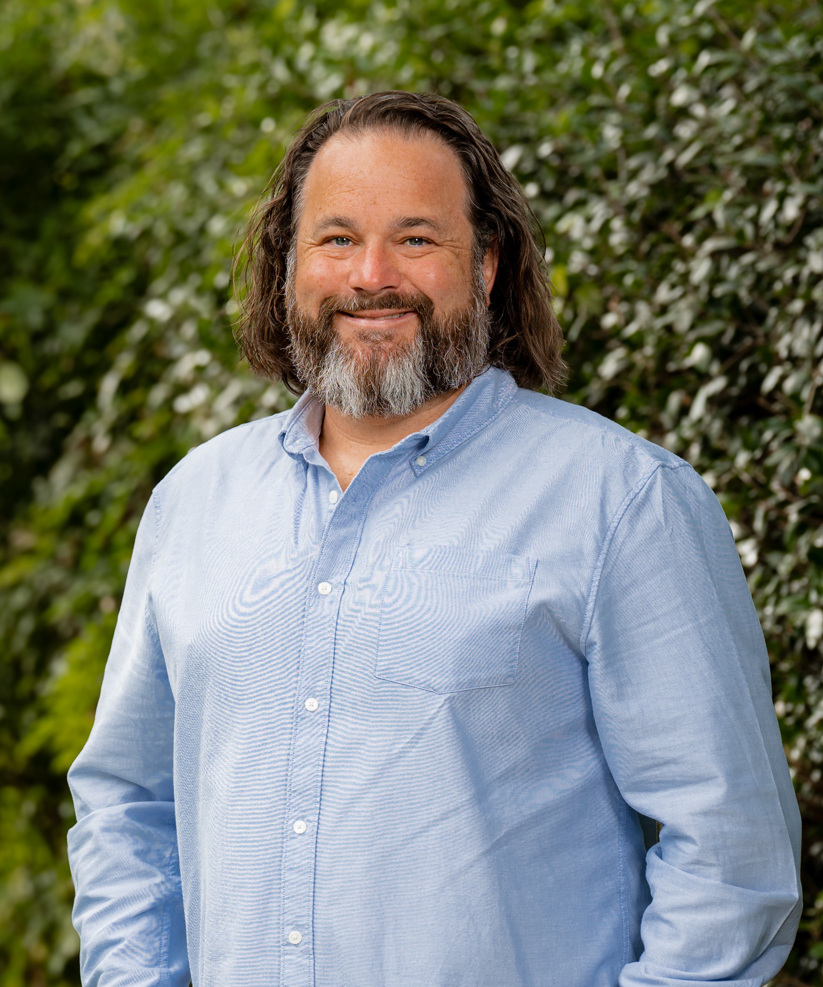 Mike Trewartha in front of a green, leafy background