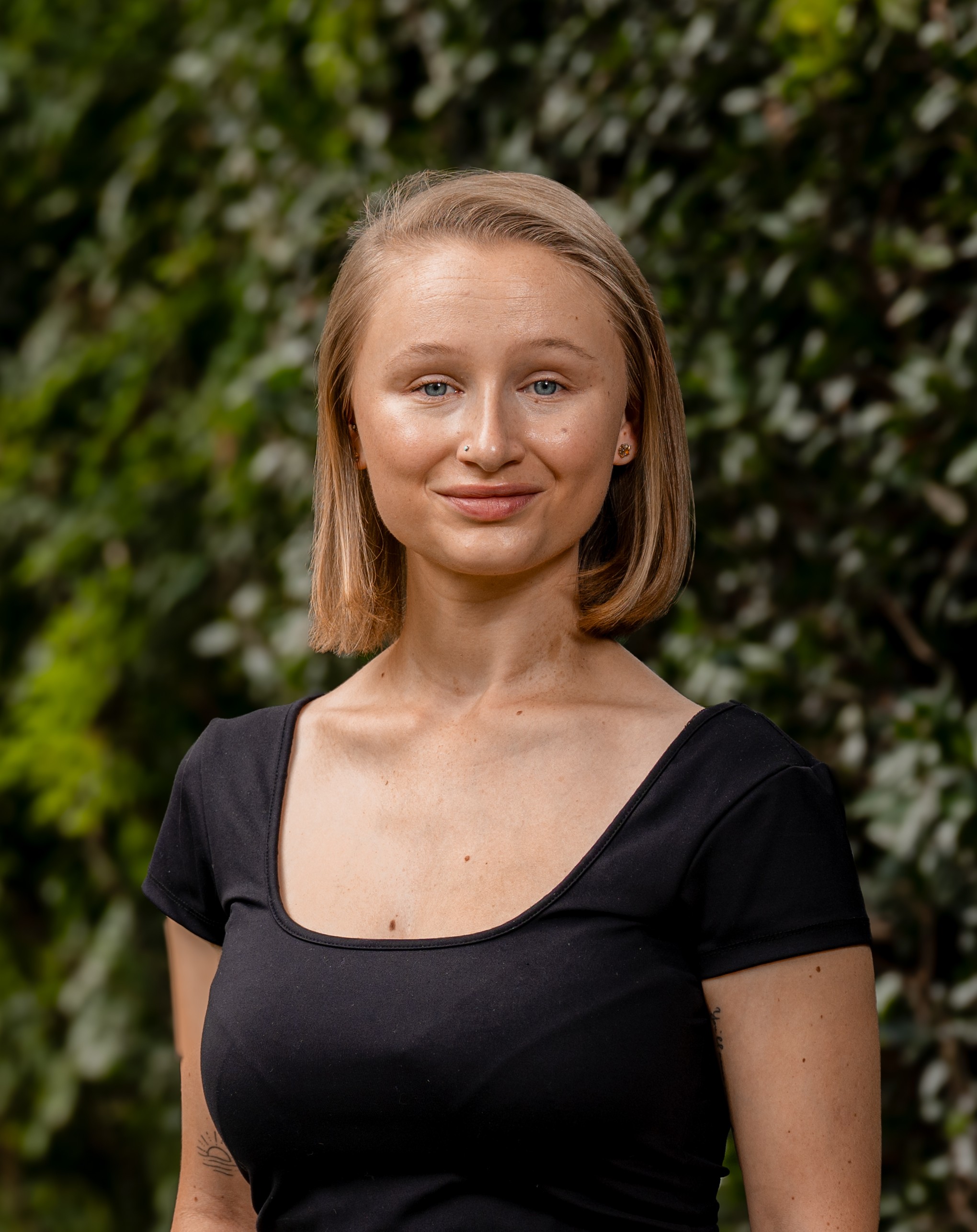 Jessica Scriven in front of a green leafy background