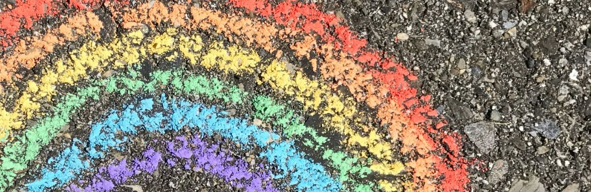 A rainbow drawn in chalk on a footpath