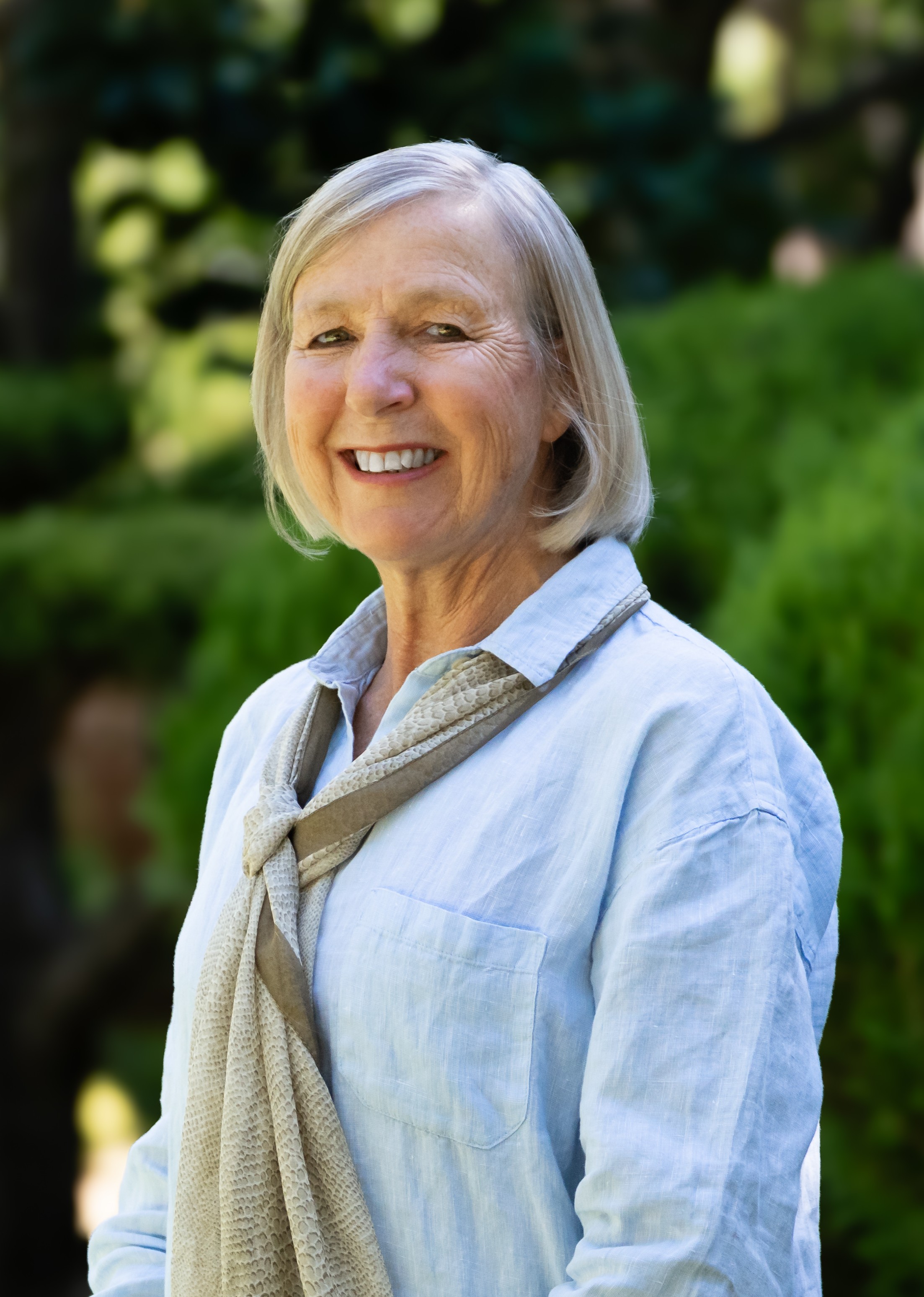 Sharon Holmes in front of a green leafy background