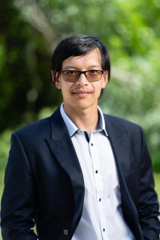 Profile picture of Greens candidate for St Albans, Bao Huynh. Bao is standing in front of blurred out parklands. Bao is wearing a light blue shirt with a dark blazer