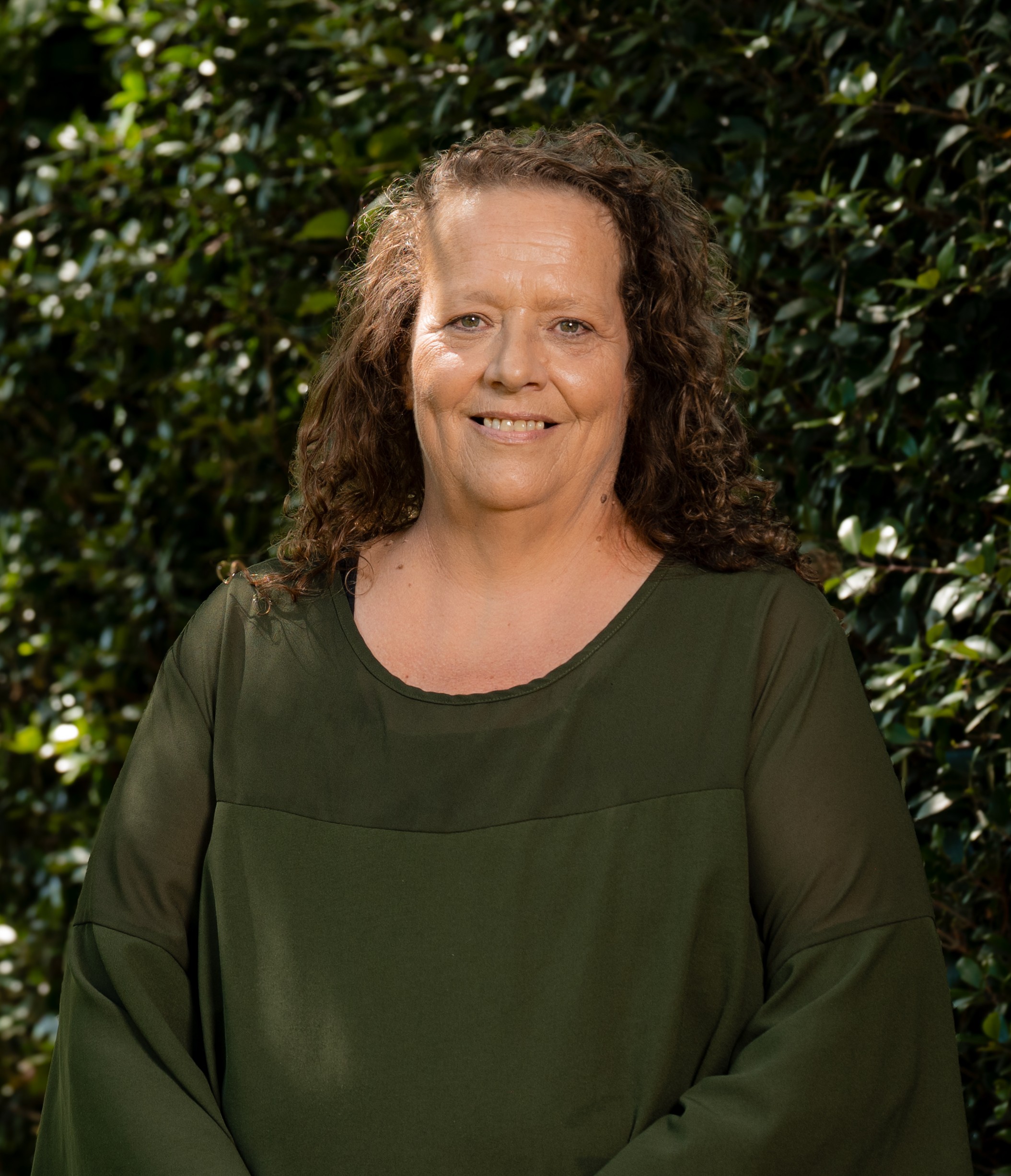 Samantha Skinner in front of a green leafy background