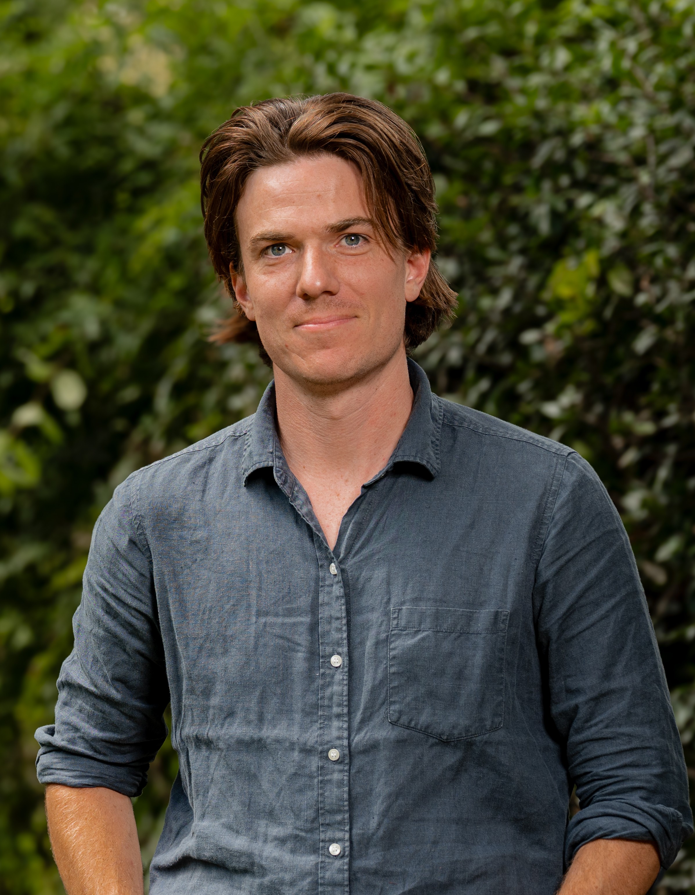 Lawrence Johnson in front of a green leafy background