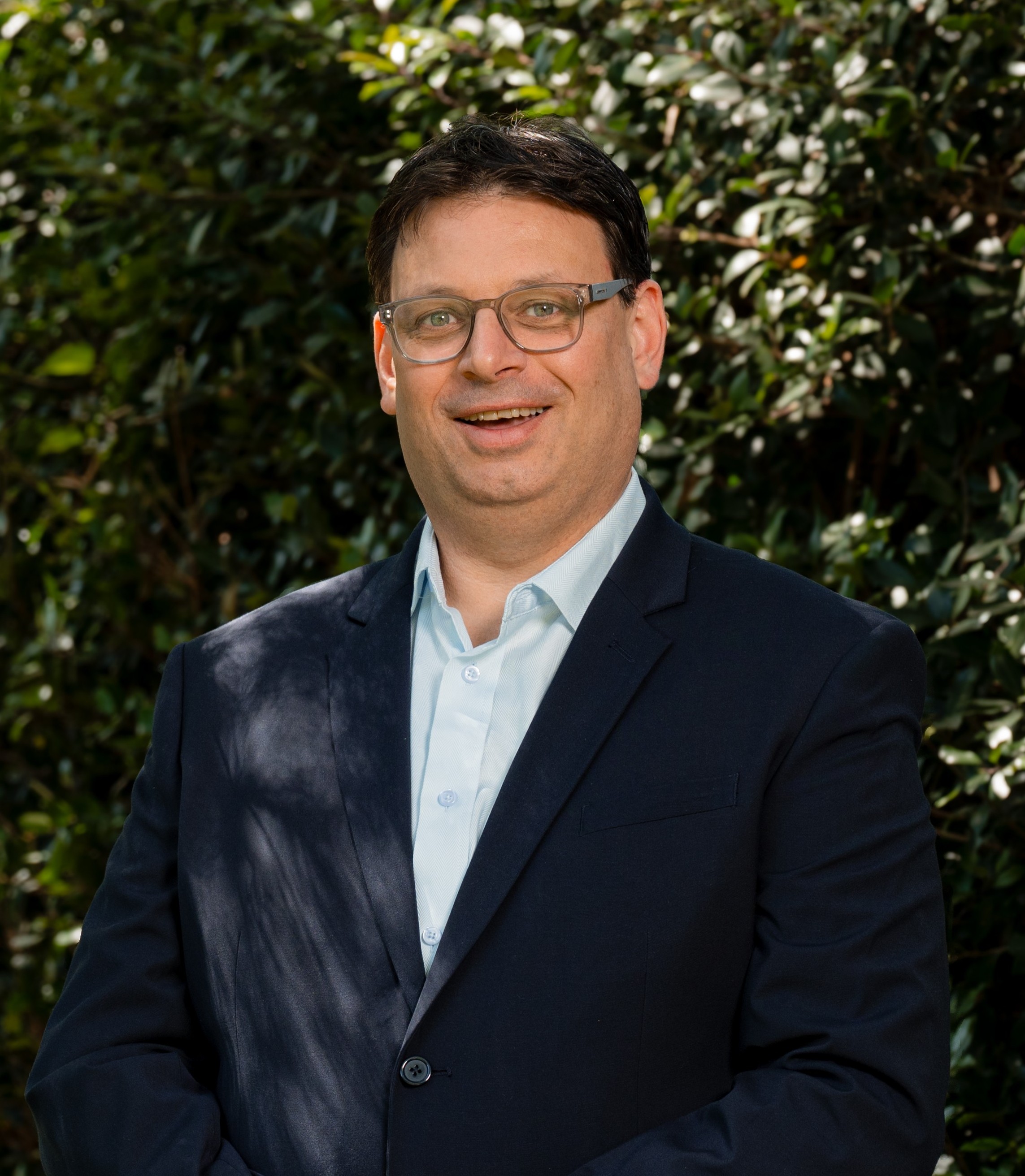 Sean Weatherly in front of a green leafy background